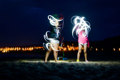Full length of illuminated lighting equipment against sky at night