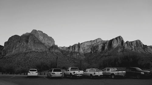 Cars on rocks against clear sky