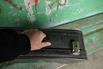 Cropped hand of man holding luggage