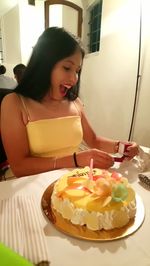 Midsection of woman with cake on table