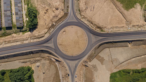 Roundabout traffic of cars and trucks on the circle ring road aerial top view. 