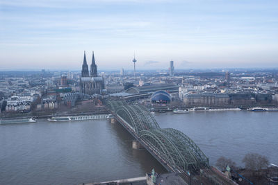 Bridge over river against buildings in city