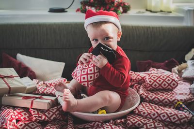 Portrait of cute baby sitting on table at home