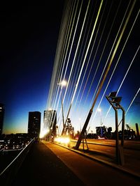 Illuminated road against sky at night