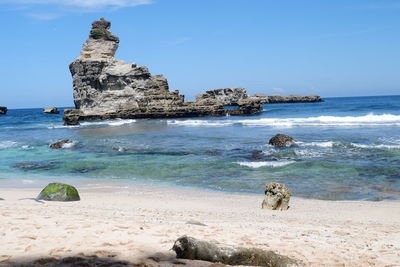 Scenic view of rocks on beach against sky