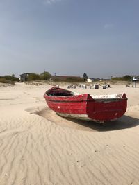 Boat moored on beach against clear sky