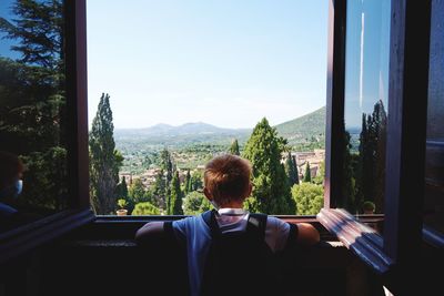 Rear view of man sitting by window