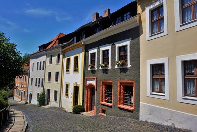 Residential building by street against sky