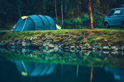 Tent on lakeshore in forest