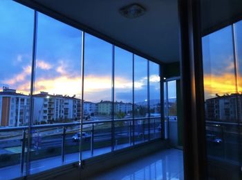 Buildings seen through glass window at sunset