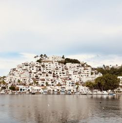 Buildings by sea against sky in city