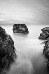Rock formation in sea against sky