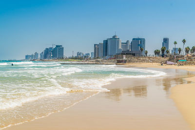 Panoramic view of beach and buildings against clear sky