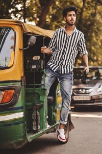 Portrait of young man standing on road