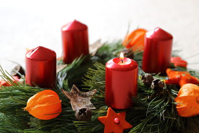 Close-up of candles with winter cherries on pine leaves