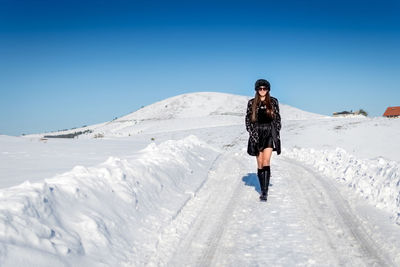 Full length of man standing on snow covered mountain