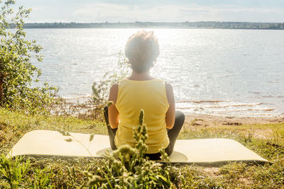 Rear view of woman looking at sea against sky