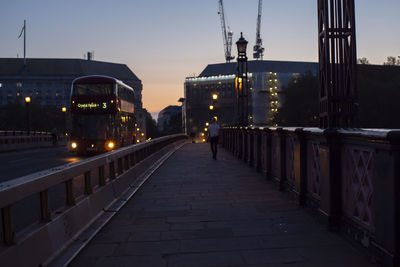 Illuminated bridge against sky at dusk