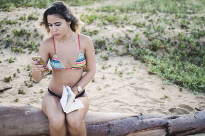Full length of woman sitting on land