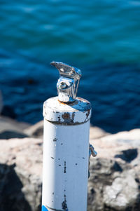 Close-up of metal container against sea