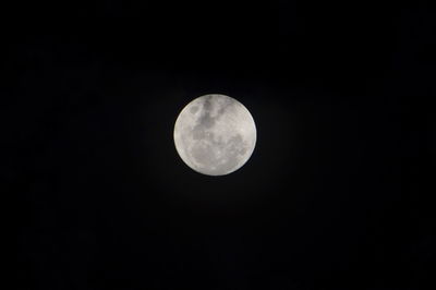 Low angle view of full moon against clear sky at night