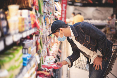 Side view of man buying in store