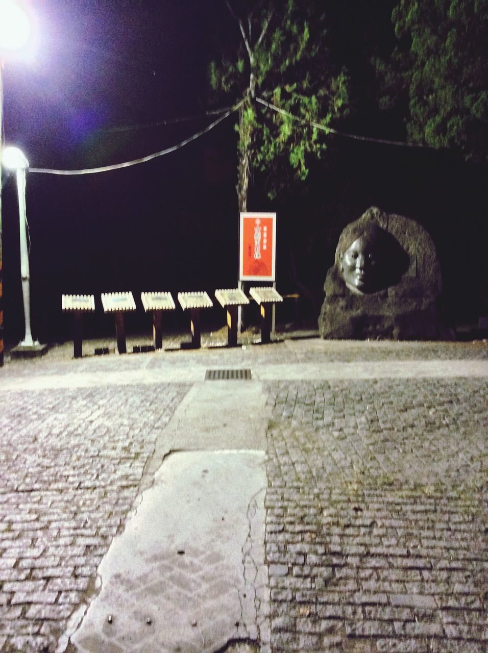 built structure, architecture, lighting equipment, wall - building feature, building exterior, street light, brick wall, text, communication, illuminated, street, the way forward, night, tree, outdoors, cobblestone, no people, sidewalk, stone wall, guidance