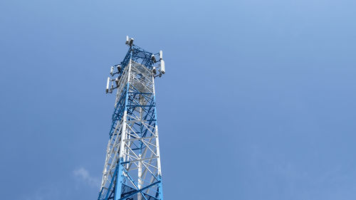 Low angle view of communications tower against blue sky