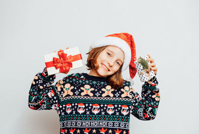 Portrait of woman wearing santa hat against white background