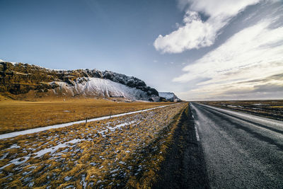 Empty road with mountains in background