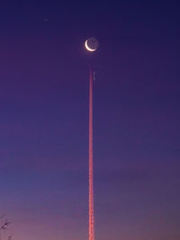 Low angle view of moon against blue sky at night