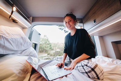 Portrait of young woman sitting in motor home