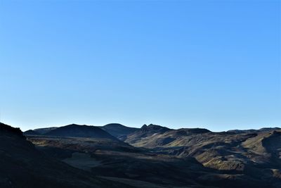 Scenic view of mountains against clear blue sky