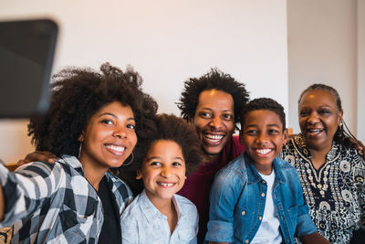 Smiling woman taking selfie with family at home