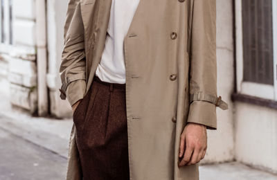 Midsection of man standing on sidewalk