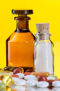 Close-up of medicine bottles against yellow background