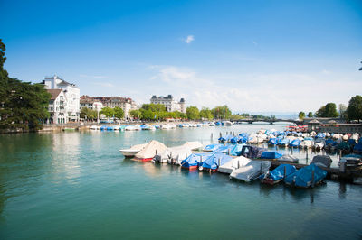 Boats moored in river against blue sky