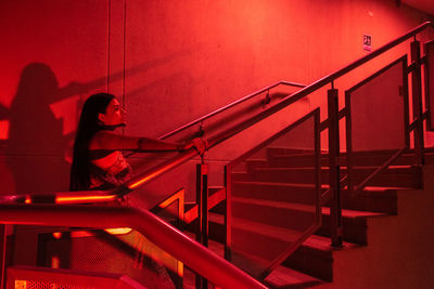 Side view of beautiful woman standing on staircase