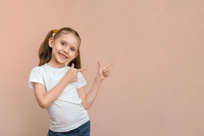 Portrait of young woman standing against wall