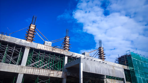 Low angle view of crane against blue sky