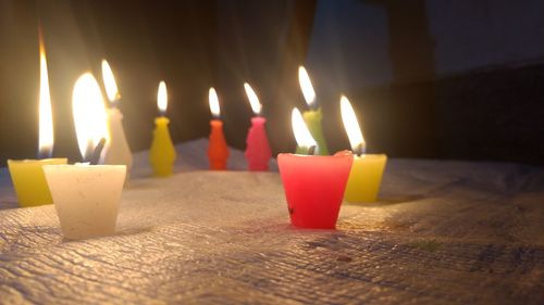 Close-up of lit candles on table