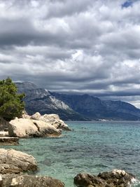 Scenic view of sea and mountains against sky