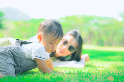 Rear view of girl lying on field