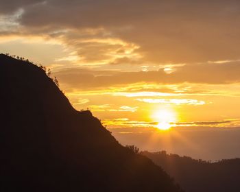 Scenic view of silhouette mountains against sky during sunset
