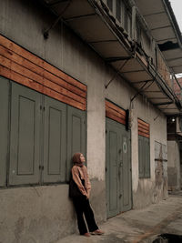 Full length of woman standing by wall outdoors