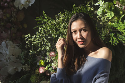 Portrait of beautiful woman against plants