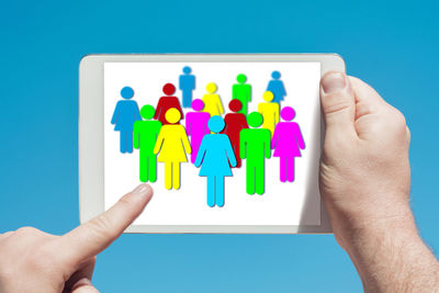 Close-up of human hand holding paper over white background