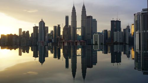 Reflection of buildings in city against sky