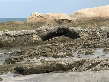 Rock formations by sea against clear sky