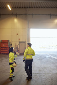 Full length of female multiracial colleagues discussing in factory